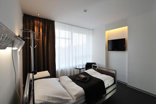 Moderná dvojlôžková izba na Avelane clinic s veľkými oknami a elegantným interiérom