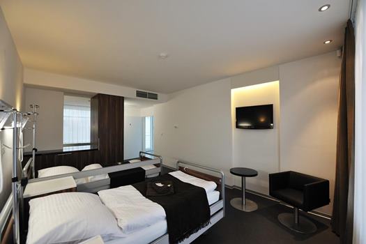 Komfortná dvojlôžková izba na Avelane clinic s TV, stolíkom a moderným osvetlením