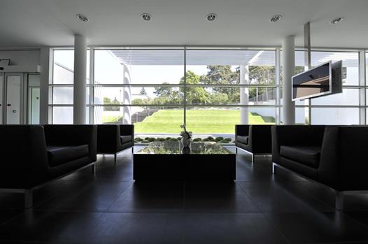 Interiér čakárne Čakáreň na Avelane clinic s čiernymi sedačkami a výhľadom na záhradu kliniky