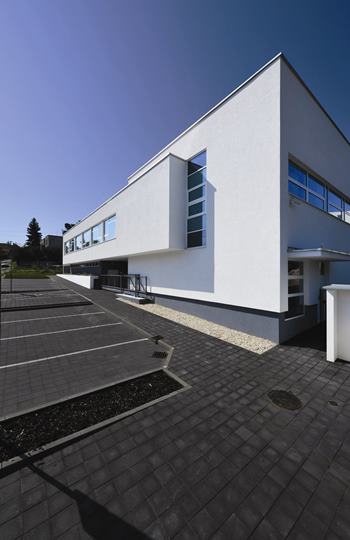 Exteriér kliniky Bočný pohľad na modernú budovu Avelane clinic s parkoviskom